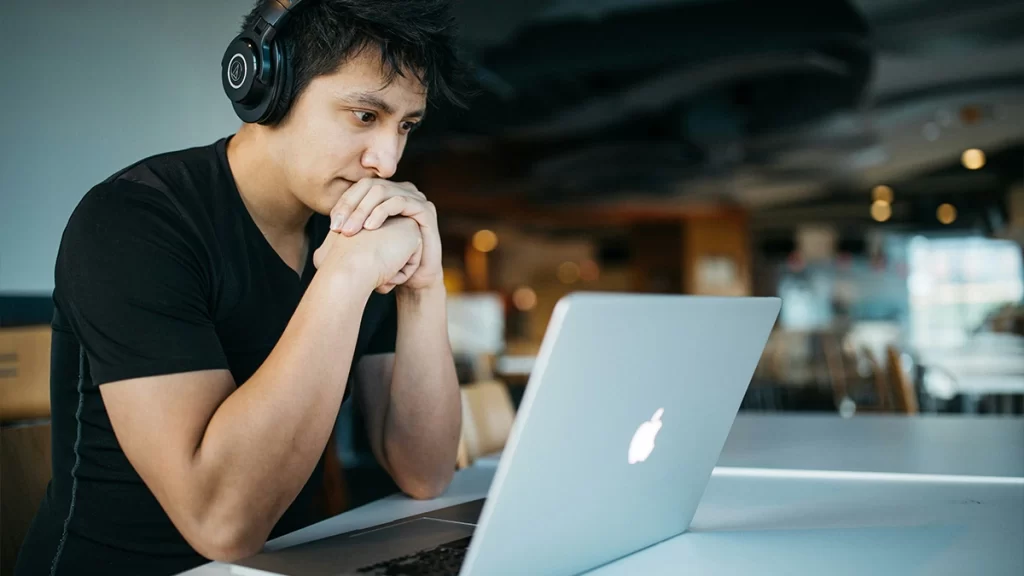 Man studying on a laptop, accessing Harvard University's free online business courses to boost his career in leadership, finance, and entrepreneurship.